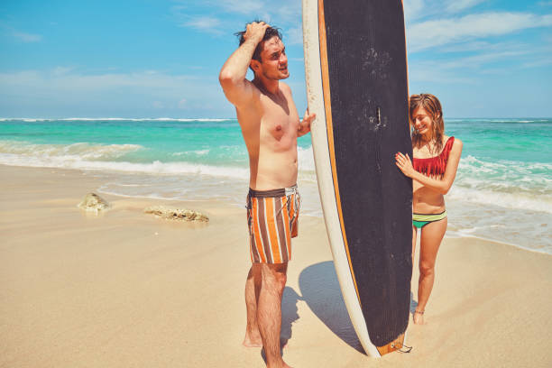istock Couple with surfboard enjoying on the tropical beach. 1134279033