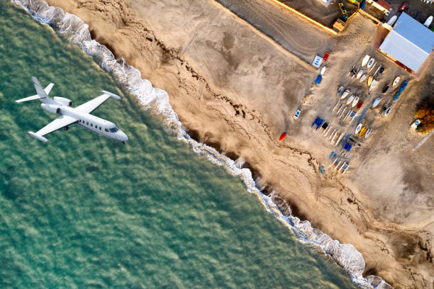 istock Airplane flying over a beach with sailboats. 1134280952
