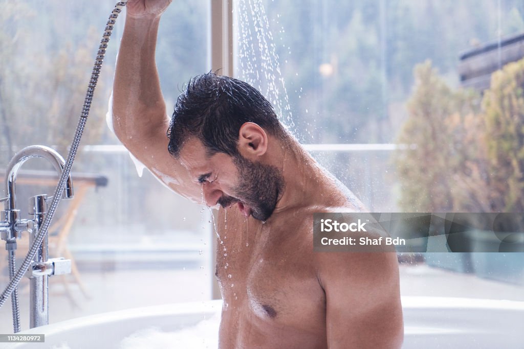 Man met douche in een jacuzzi met uitzicht op het bos - Royalty-free Douche Stockfoto