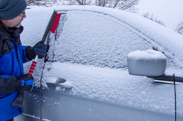 istock Man brushing snow off a car 1134281338