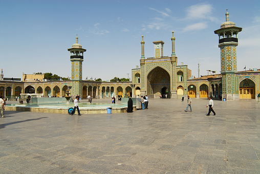 Qom, Iran - June 26, 2007: Unidentified people walk in front of the Fatima Masumeh Shrine in Qom, Iran. Qom is considered by Shia Muslims one of the most sacred cities in Iran.