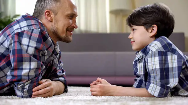 Caring dad praising his little son, fathers care and support, time together