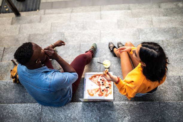 przyjaciele jedzący pizzę na świeżym powietrzu - pizza eating african descent lunch zdjęcia i obrazy z banku zdjęć
