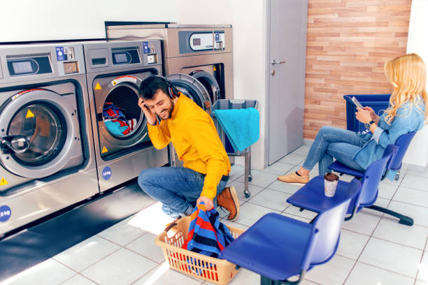 el hombre joven lavando su ropa - all laundry detergent audio fotografías e imágenes de stock