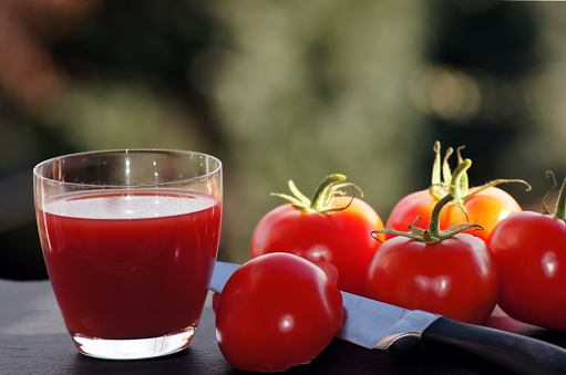 Red tomatoes with a glass of tomato juice