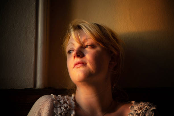 istock beautiful young woman in window light 1134288073