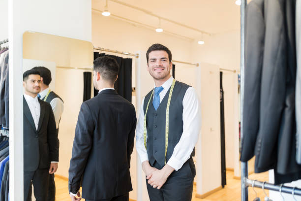 istock Designer Standing By Client Wearing Suit At Rental Store 1134288087
