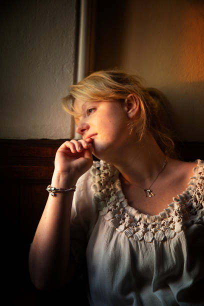 istock beautiful young woman in window light 1134288116