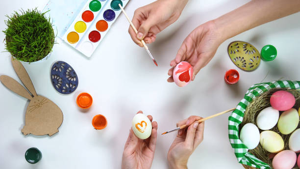 istock Women decorating eggs, traditional Easter activities for fun, happy holidays 1134288172