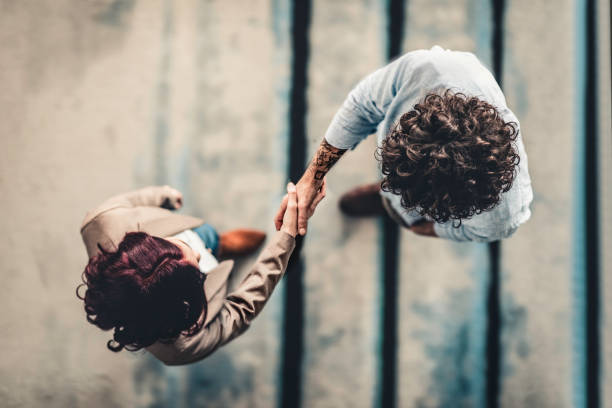 manager maschio che stringe la mano alla candidata donna - recruiter foto e immagini stock