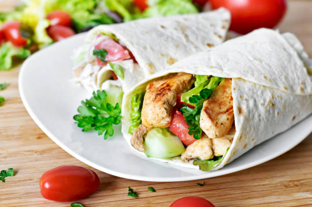 Delicious fresh chicken wrap, closeup shot Delicious fresh chicken wrap, closeup shot. Tasty tortilla with salad and turkey meat,healthy eating scene. fajita photos stock pictures, royalty-free photos & images