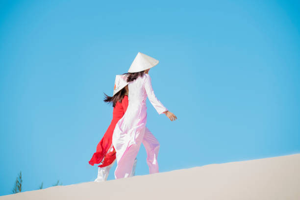 Beautiful woman with vietnam culture traditional ,vintage style,Ao Dai traditional,vietnamese women in Ao Dai traditional at white sand beach.