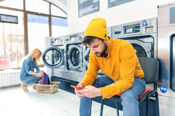 el hombre joven lavando su ropa - all laundry detergent audio fotografías e imágenes de stock