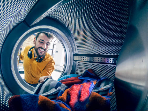 el hombre joven lavando su ropa - all laundry detergent audio fotografías e imágenes de stock