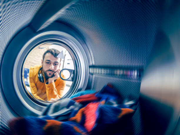 el hombre joven lavando su ropa - all laundry detergent audio fotografías e imágenes de stock