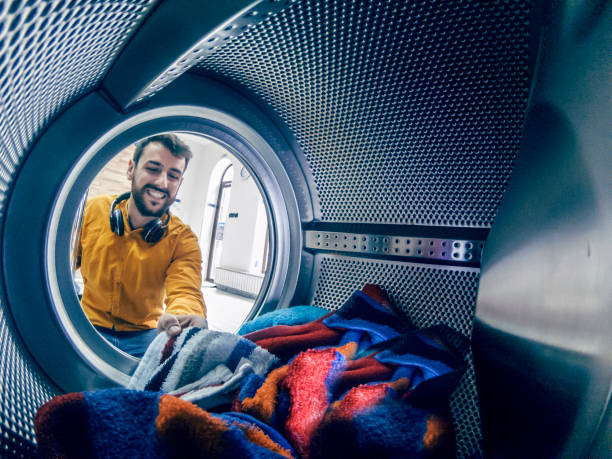 el hombre joven lavando su ropa - all laundry detergent audio fotografías e imágenes de stock