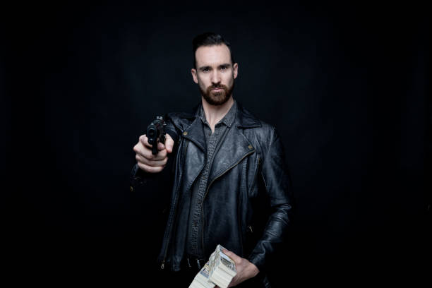istock Man holding gun and cash 1134298285