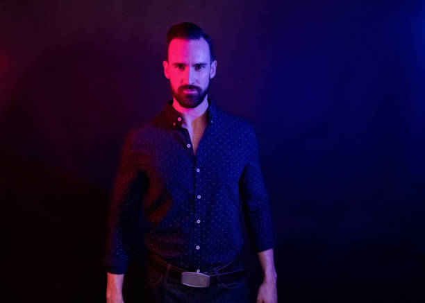istock Handsome man with blue shirt with color lighting 1134298500