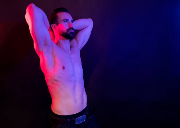 istock Sexy shirtless man with red and blue lighting 1134298579