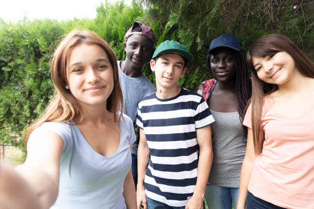 gruppo multirazziale di adolescenti nel parco scolastico che fanno un selfie - solo adolescenti foto e immagini stock