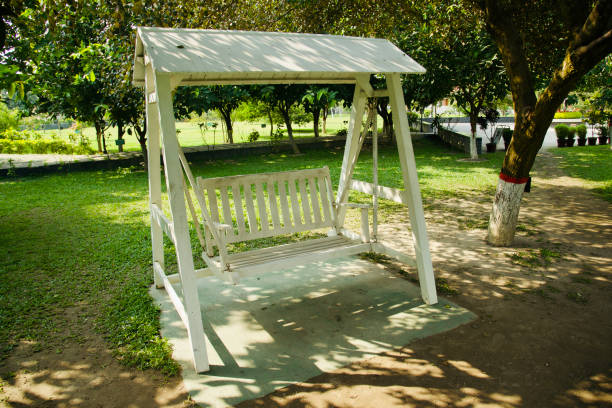 A wooden swing chairs around a park unique photo