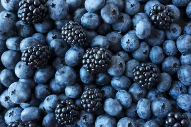 Texture berries close up. Top view. Black and blue berries. Ripe blueberries and blackberries. Various fresh summer berries. Mix berries.