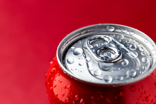 Macro view of water condensation over red aluminium can with copy space