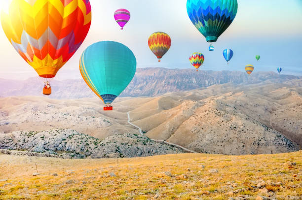 istock Hot air balloon flying over amazing mountains 1134305990