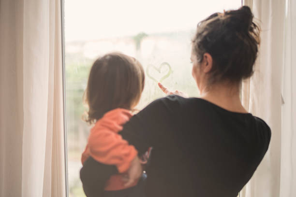 istock Mother and son looking out of window 1134306215