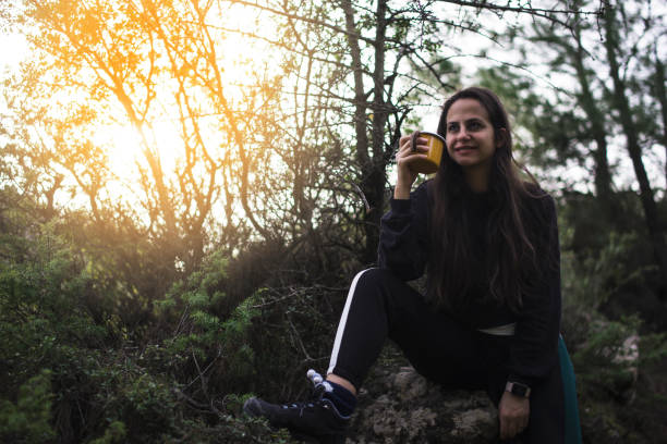 istock Young Woman Holding Coffee Cup in Nature 1134307434
