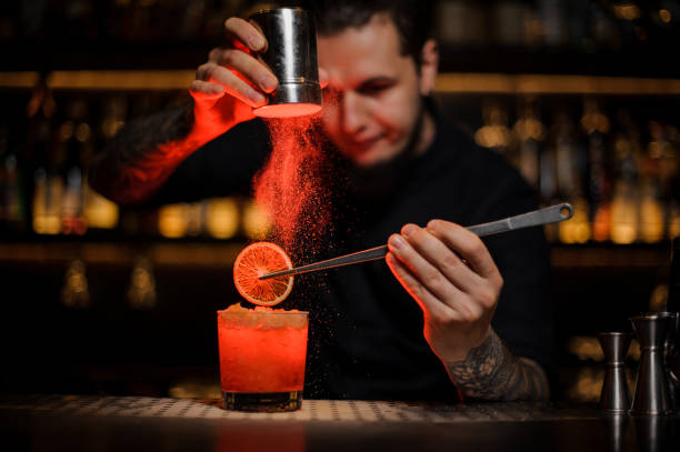 istock Barman adding to an alcoholic cocktail a dried orange and powder 1134310083