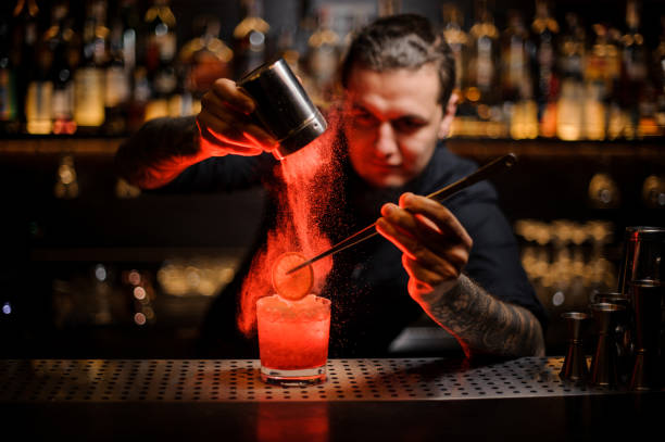 istock Bartender adding to a cocktail a dried orange and powder 1134310099