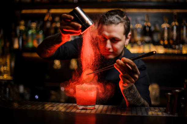istock Bartender adding to an alcoholic cocktail a dried orange and powder 1134310727