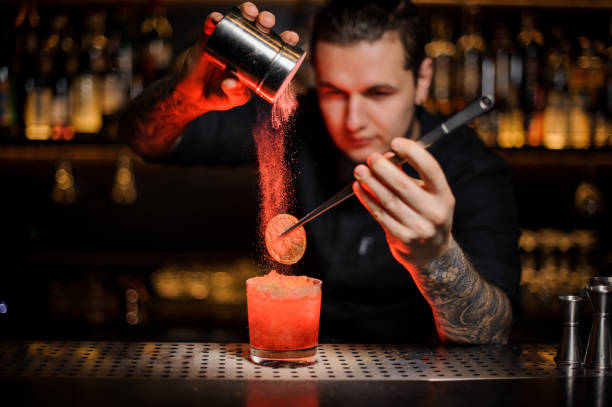 istock Professional bartender adding to an alcoholic cocktail a dried orange and powder 1134311044
