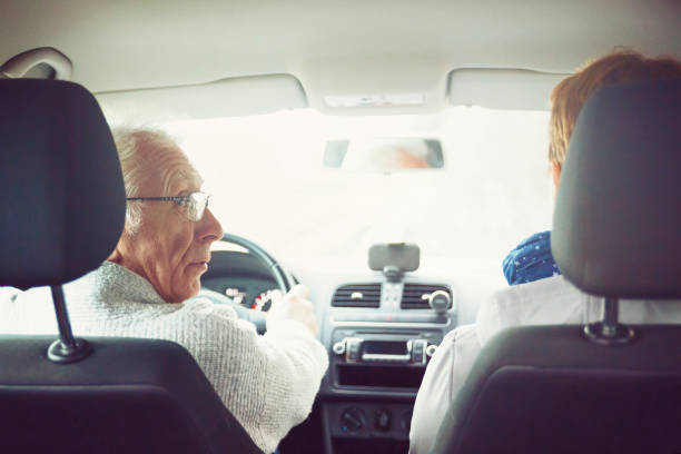 istock Old man drives his car and looks over his shoulder 1134311439