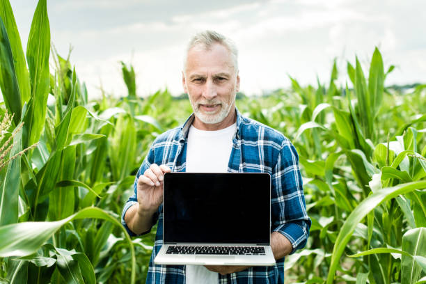 istock Farmer in the field showing laptop screen 1134312060