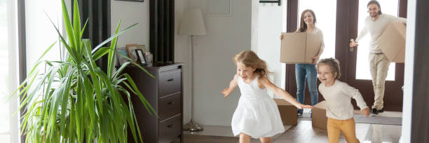 istock Children running into new house parents with boxes on background 1134312122