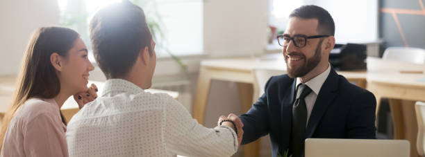 istock Confident Real Estate Agent greeting clients young married couple in office 1134312126
