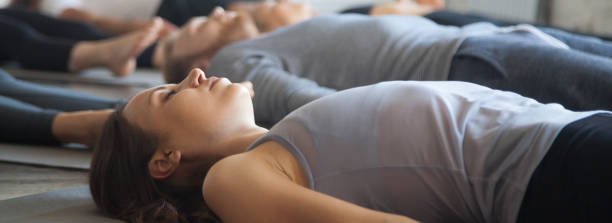 istock Horizontal image group yoga session people practice Savasana Corpse pose 1134312153