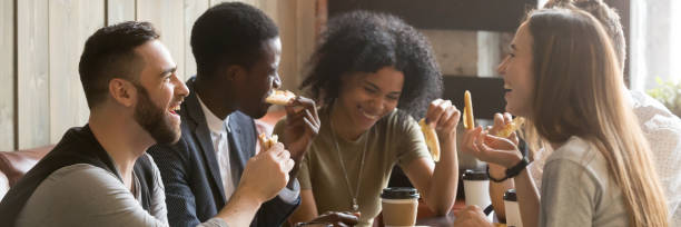 horizontal image multiracial friends drinking coffee eating pizza at cafe - pizza eating african descent lunch imagens e fotografias de stock