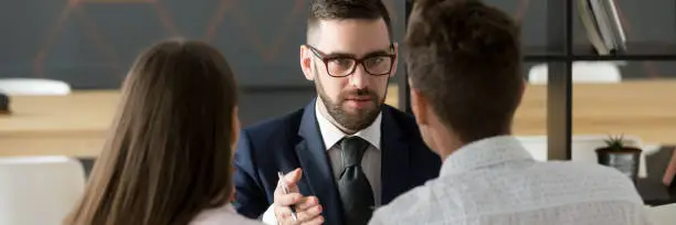 Photo of Rear view couple meets with Real Estate Agent or real estate agent