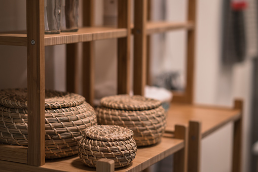 Decorative wicker baskets in bathroom shelf