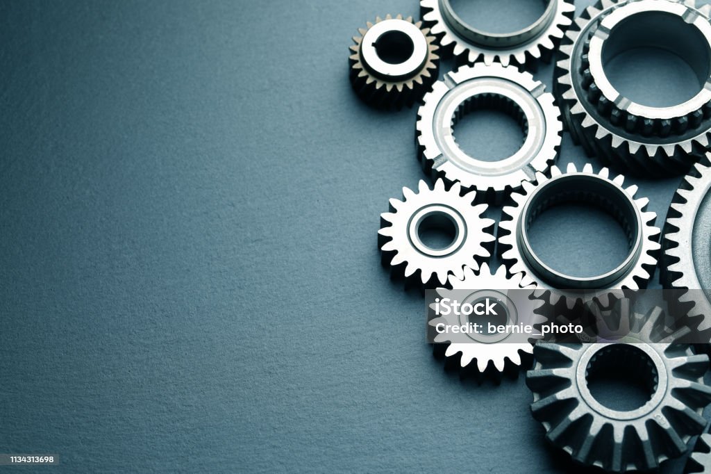 Machine Gears Mechanical gears on black slate background; top view Gear - Mechanism Stock Photo
