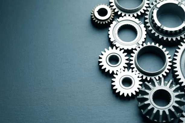 Mechanical gears on black slate background; top view