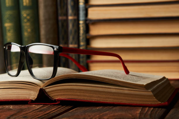istock Old books and reading glasses on desk in library room 1134317134