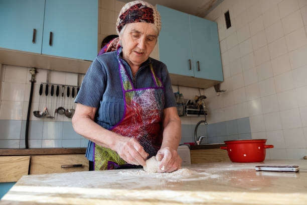 starsza kobieta ugniata ciasto w kuchni domowej, babcia gotuje wypieki, świeży chleb, smaczne ciasto - grandmother pie cooking baking zdjęcia i obrazy z banku zdjęć