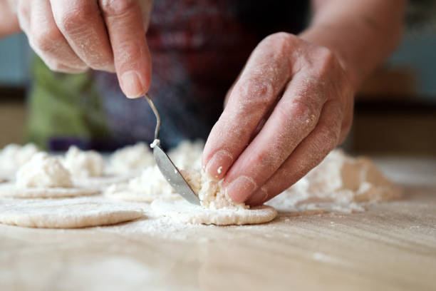 istock Rolled dough with cottage cheese on wooden table. Process of making homemade dumpling, traditional Russian cuisine 1134321109