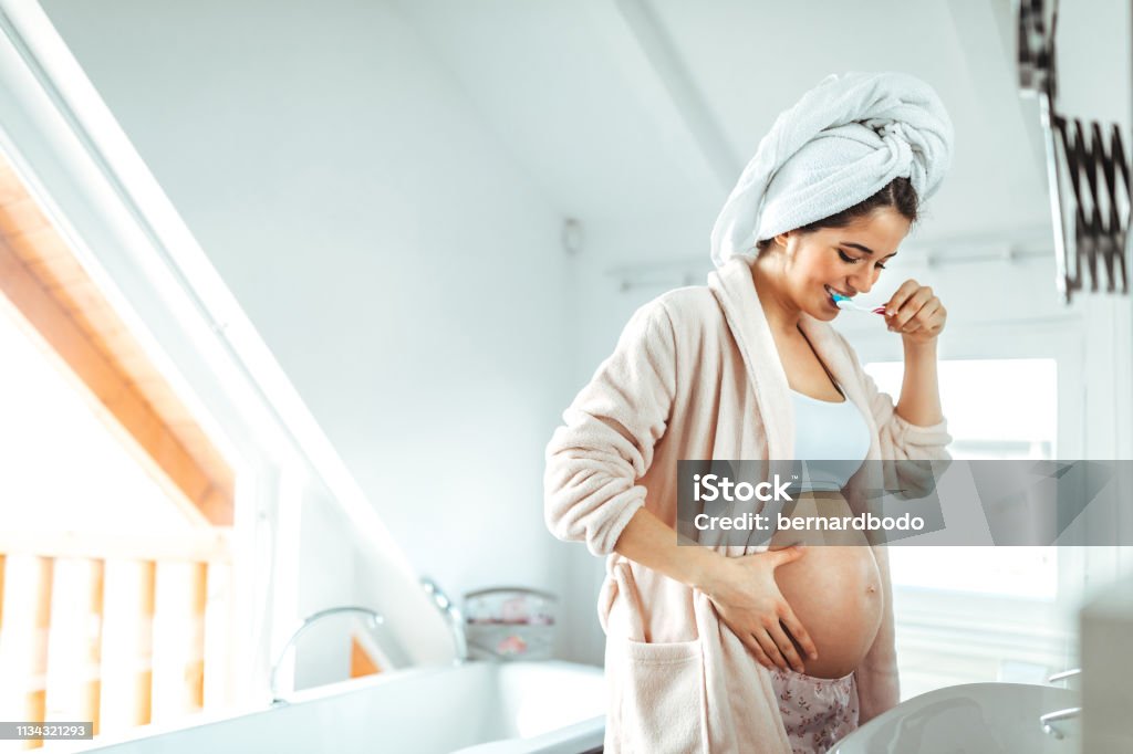 The secret to a great smile Pregnant female brushing teeth at home Pregnant Stock Photo