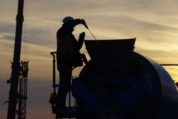 Schinveld, the Netherlands, - October 17, 2018. Worker cleaning the cement miser on the construction site .