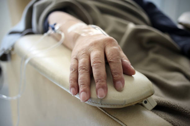 Chemo hand Buenos Aires, Argentina - March 08, 2019: Chemo therapy and serum treatment dripping drop passing through the lines in a hospital in Buenos Aires, Argentina infused stock pictures, royalty-free photos & images